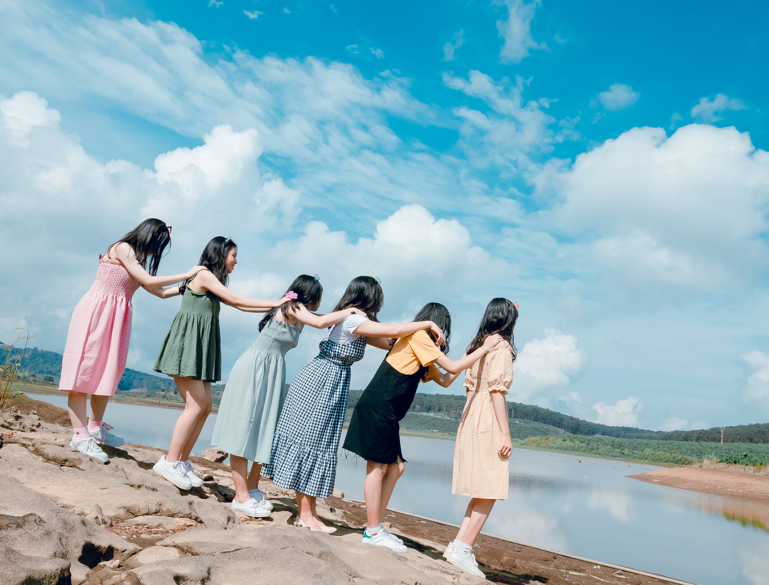 Group of women enjoying a sunny day by the lake, showcasing togetherness and joy.
